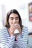 Beautiful young woman with eyes closed holding mug