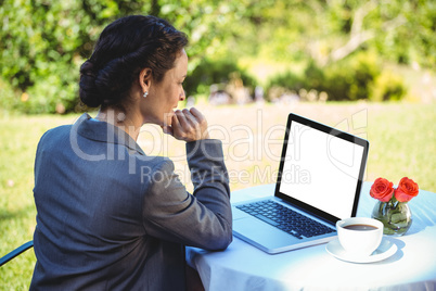 Businesswoman having coffee using her laptop