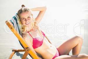 Portrait of young woman sitting on an armchair on the beach