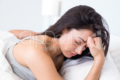 Upset woman lying on bed