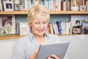 Senior woman using digital tablet at home