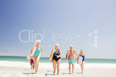 Senior friends holding surfboard