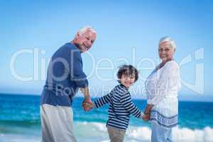 Cute boy holding his grandparents hands