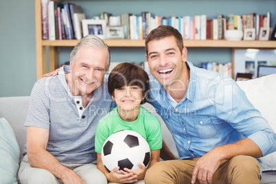 Portrait of happy multi genration family with football