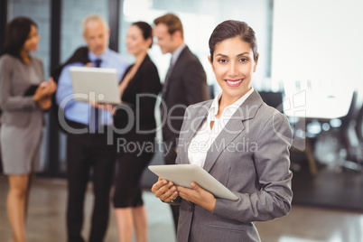 Portrait of happy businesswoman holding digital tablet