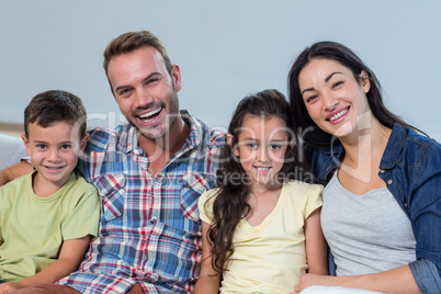 Family sitting on sofa and smiling