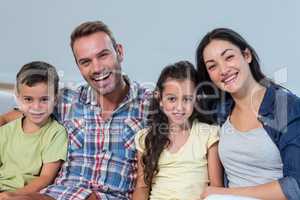 Family sitting on sofa and smiling