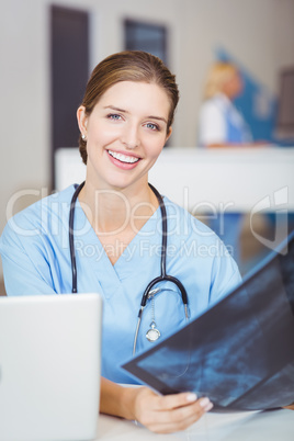 Portrait of smiling female doctor holding X-ray