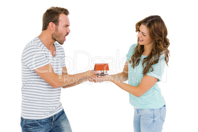 Happy young couple holding model house