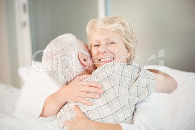 Happy senior woman hugging husband