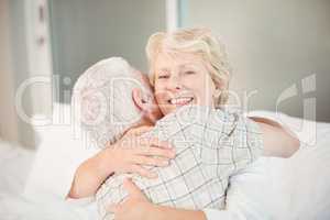 Happy senior woman hugging husband