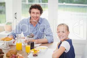Girl having breakfast with father