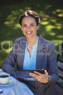 Businesswoman using tablet with coffee