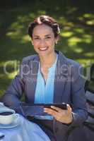 Businesswoman using tablet with coffee