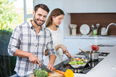 Man helping woman in preparing food at home