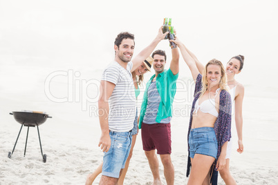 Group of friends toasting beer bottles on the beach