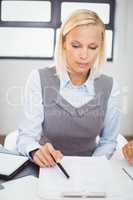 Businesswoman reading documents in office