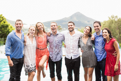 Cheerful friends standing by swimming pool