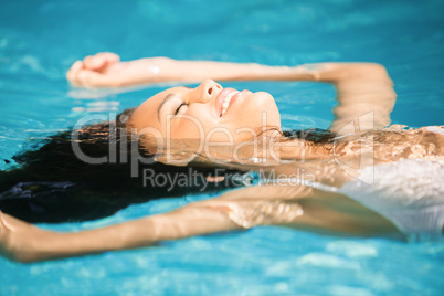 Beautiful woman floating in pool