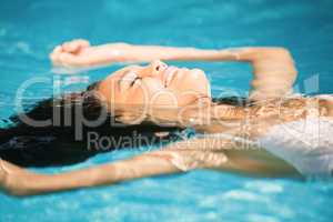Beautiful woman floating in pool
