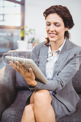 Businesswoman using digital tablet while sitting in office