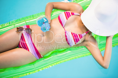 Beautiful woman relaxing on air bed in swimming poo