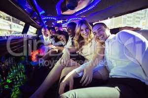 Happy friends chatting in limousine