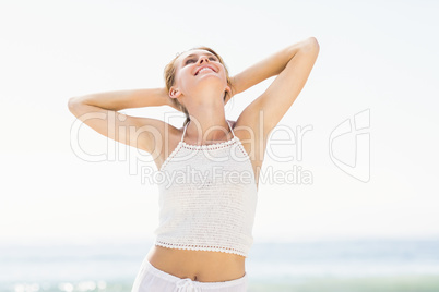 Beautiful woman stretching her arms on the beach