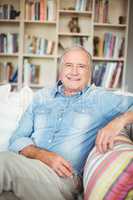 Portrait of happy senior man sitting on sofa