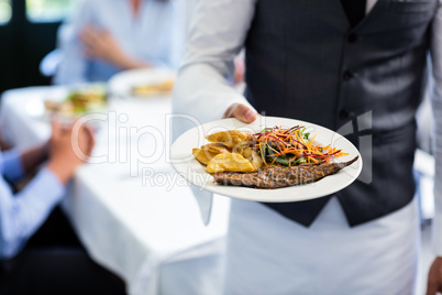 Waiter holding a plate of meal