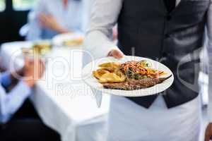 Waiter holding a plate of meal