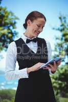 Smiling waitress taking an order with a tablet
