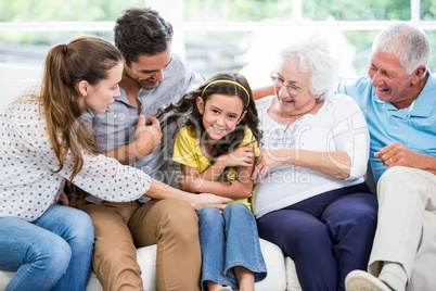 Smiling multi-generation family sitting on sofa