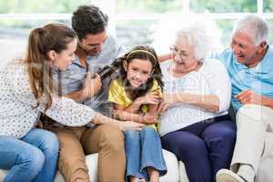 Smiling multi-generation family sitting on sofa
