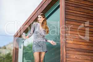 Beautiful young woman standing by glass railing