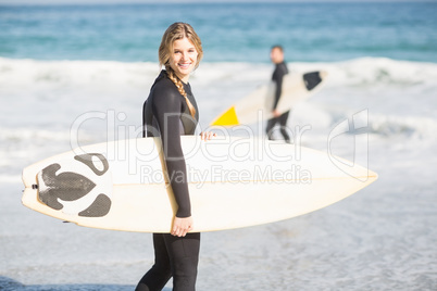 Surfer walking on the beach with a surfboard