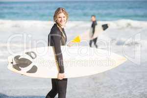 Surfer walking on the beach with a surfboard