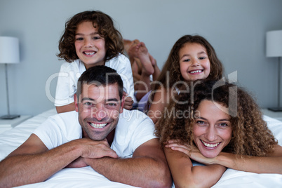 Portrait of family lying on top of each other