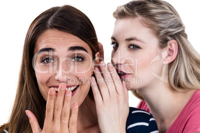 Woman whispering in friend ear