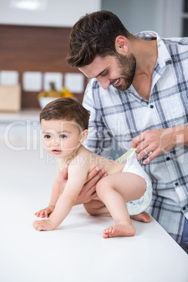 Father checking diaper of son