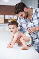 Father checking diaper of son