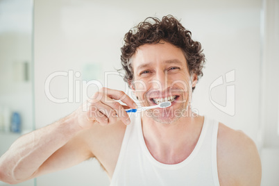 Portrait of young man brushing teeth