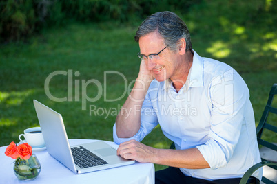 Casual businessman using laptop daydreaming