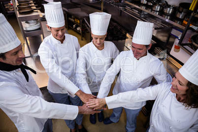 Team of chefs putting hands together