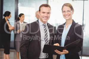 Portrait of businessman and businesswoman holding file