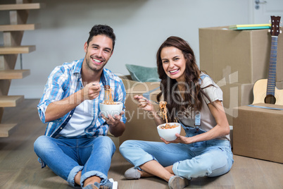 Portrait of Smiling couple having noodles