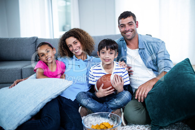 Portrait of family watching american football match on televisio