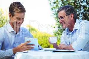 Two businessmen meeting in a restaurant using tablet