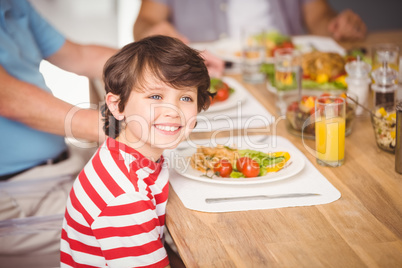 Happy boy having breakfast with family