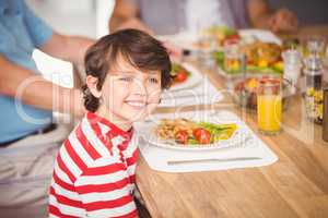 Happy boy having breakfast with family